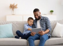 young-black-father-and-little-son-using-tablet-at--D8PFF4B